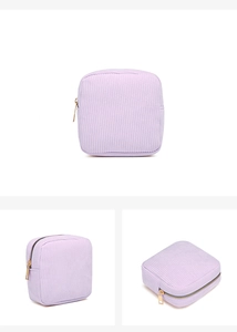 Detail view of purple corduroy cosmetic bag with a gold zipper and ribbed texture