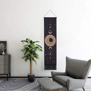 Tenture bohème avec soleil et lune dorés sur tissu noir orné de pompons élégants