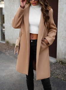 Detail of camel wool coat sleeve with button decor and white ribbed turtleneck top
