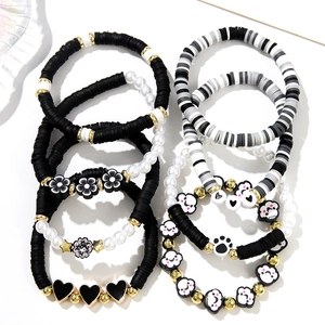 Detailed flat lay of 8-piece beaded bracelet set with heart, flower and cloud charms