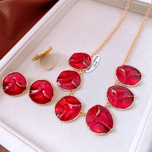 Detail of red enamel gold necklace set with vintage wrinkled texture in a jewelry box