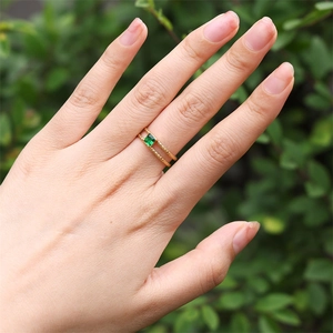 Detail of 18K gold-plated double-band ring featuring a square green zircon stone on hand