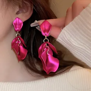 Elegant rose red leaf petal tassel earrings with gold rings on model in sunlight