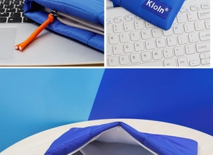 Close-up of blue quilted laptop bag with orange zipper pull and Kloln brand label detail