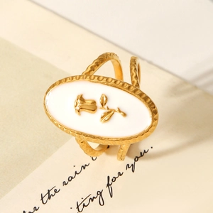 Detailed close-up of a gold rose ring with white enamel and a textured hammered band