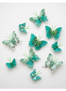 Detailed view of 10-piece green butterfly ornaments with glitter, pearls and metal clips