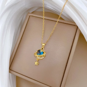 Close-up of gold galaxy necklace with blue celestial pendant and sparkling crystal halo
