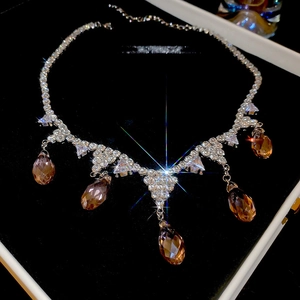 Close-up of zircon tassel necklace with champagne teardrop pendants on black jewelry box