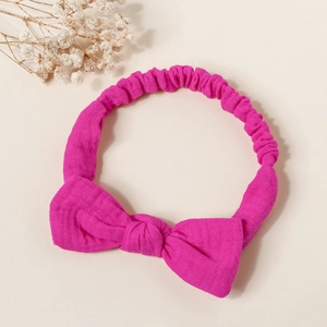 Macro view of rose red bow headband featuring soft crinkle gauze texture and elastic band