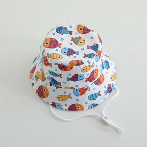Close-up of white toddler sun hat with colorful cartoon fish prints and adjustable chin strap