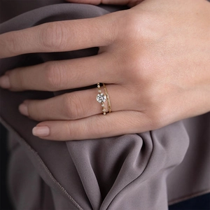 Detail of luxury gold double-ring set featuring a solitaire diamond and minimal band