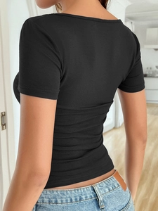 Back view of a slim fit black Y2K T-shirt with star print on a model in a room