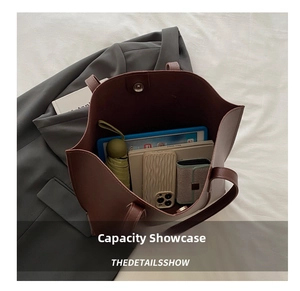 Top view of spacious brown leather tote bag interior with tablet and daily essentials