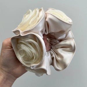 Detail view of double-layered satin rose scrunchie in creamy white silk organza