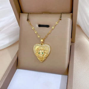 Detail of gold heart lion pendant with green zircon eyes and shimmering pavé diamonds