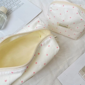 Detail der weiß gestreiften Kosmetiktasche mit rosa Herzen, Reißverschluss und Stauraum