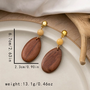 Detail view of geometric wooden teardrop earrings with dimensions 6.7cm by 2.3cm