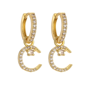 Macro shot of gold crescent moon earrings encrusted with sparkling cubic zirconia stones