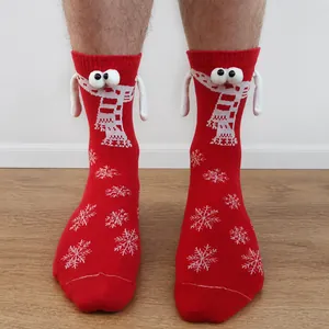 Detail of red Christmas socks with 3D eyes and snowflake patterns in cotton blend