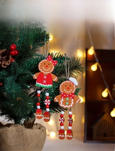 Detail of wooden gingerbread ornaments with beaded legs hanging on a Christmas tree