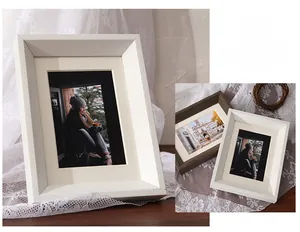 Detail of solid wood photo frames in white and dark brown with elegant inner mats