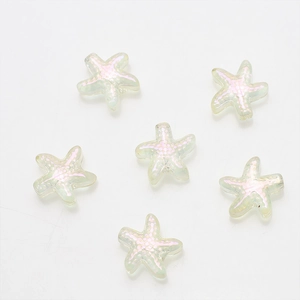 Close-up of six starfish-shaped glass charms with a pink pearlescent finish for DIY jewelry