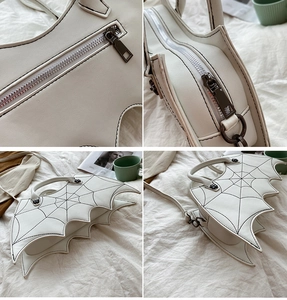 Detail view of white bat-wing shaped PU bag with intricate spider web embroidery