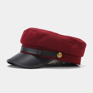 Detail of vintage navy hat with dark red fabric body and black faux leather brim texture