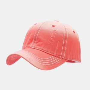 Detailed view of coral pink washed canvas baseball cap with vintage distressed edges