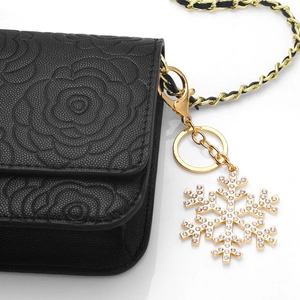 Black camellia embossed crossbody bag with golden chain and crystal snowflake pendant
