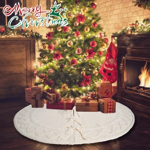 Detail view of white knitted Christmas tree skirt with festive patterns and ribbon ties