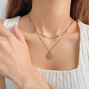 Gros plan d'un collier double couche avec pendentif rose et perles colorées sur modèle