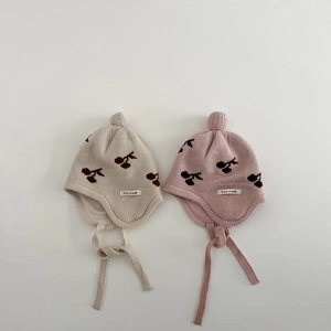 Detail of infant knit hats with cherry patterns, ear flaps, and plush pom-poms on top