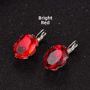 Detailed view of bright red oval-cut zircon earrings with silver alloy hook settings