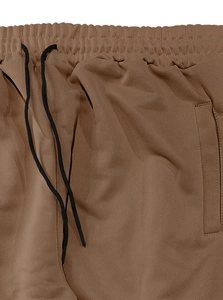 Detail of coffee brown joggers featuring an elastic waistband and black drawstrings