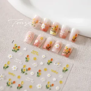 Detail showing matte orange tulip nail stickers and gold floral press-on nail set