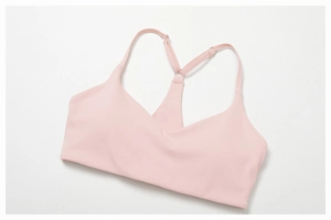 Detail view of pink V-neck sports bra with Y-back straps and soft brushed fabric texture