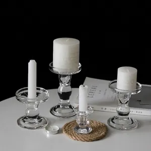 Set of minimalist glass candle holders in various shapes with white pillar candles