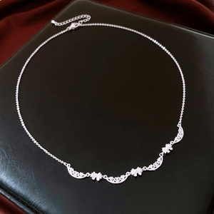 Detailed silver bow necklace showing delicate hollow lace work and adjustable clasp chain