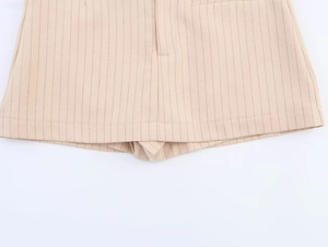 Vue détaillée de l'ourlet du short rayé et de la texture du tissu tissé de qualité