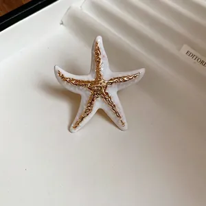 Bohemian wrinkled starfish open ring in ceramic white with golden textured relief