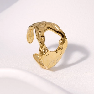 Golden irregular lava textured adjustable stainless steel ring on white background