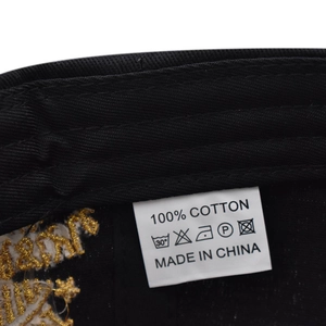 Detail of 100% cotton label and premium gold embroidery stitching on a black baseball cap