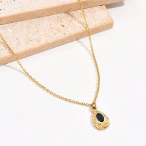 Gold water drop necklace with deep blue zircon and hammered metal texture detail