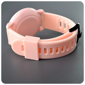 Detail view of pink silicone sports watch strap with contrast black plastic buckle
