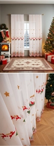 Detail von Rentier- und Schneeflocken-Stickereien auf weißem, transparentem Weihnachts-Store