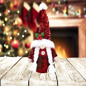 Gnome de Noël avec bonnet à paillettes rouges sur une surface en bois rustique
