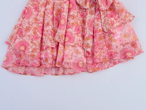 Dettaglio dell'orlo a balze in chiffon a strati con stampa floreale rosa vintage