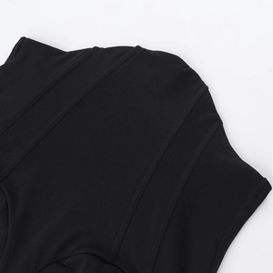 Détail des coutures verticales sur un haut noir ajusté avec texture en dentelle fine