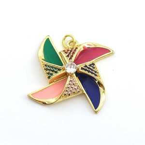 Vue macro d'un pendentif moulin à vent plaqué or 18K avec émail coloré et zircons fins